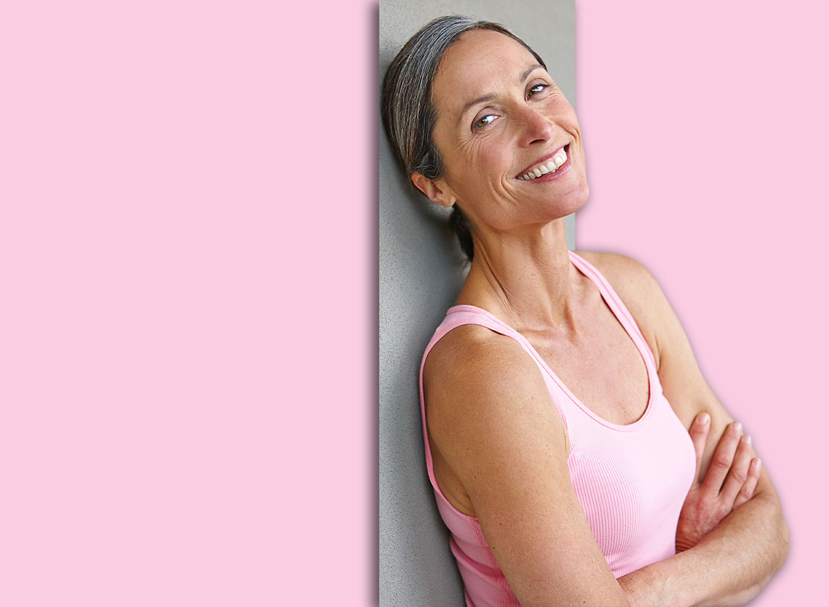 Gray wall, woman and arms crossed for fitness with pride for exercise, workout or health in Germany. Mature person, happy and mockup space for yoga as hobby or activity for self care on portrait