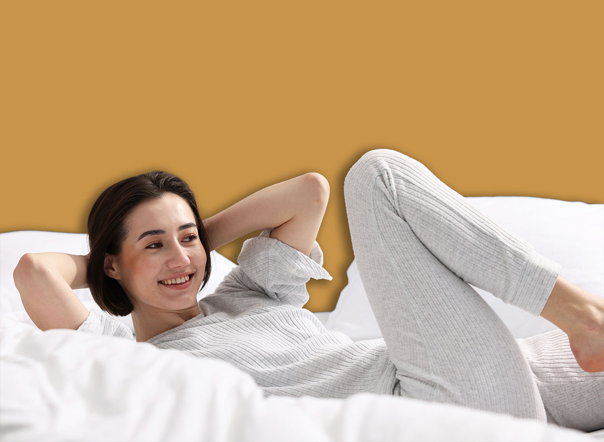 Young woman exercising on bed at home. Morning routine