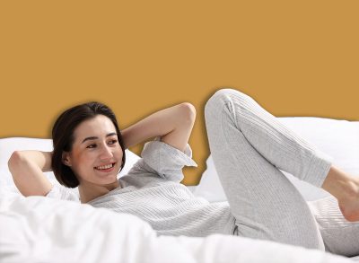 Young woman exercising on bed at home. Morning routine