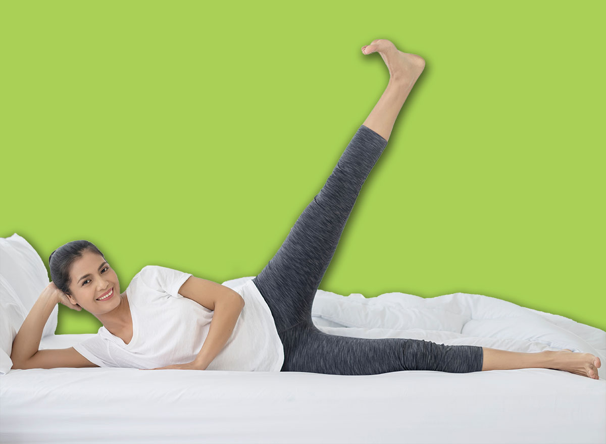 Healthy and Relaxation concept. Asian woman doing yoga exercise on bed at home. Morning workout in bedroom.