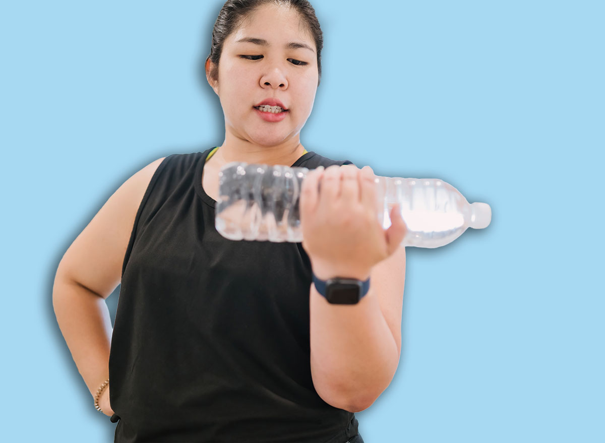 fat woman using water bottle exercise to save environment. thoughtful chubby woman lifting water bottle workout concern planet. motivated fat woman reuse plastic bottle to exercise instead of tool.