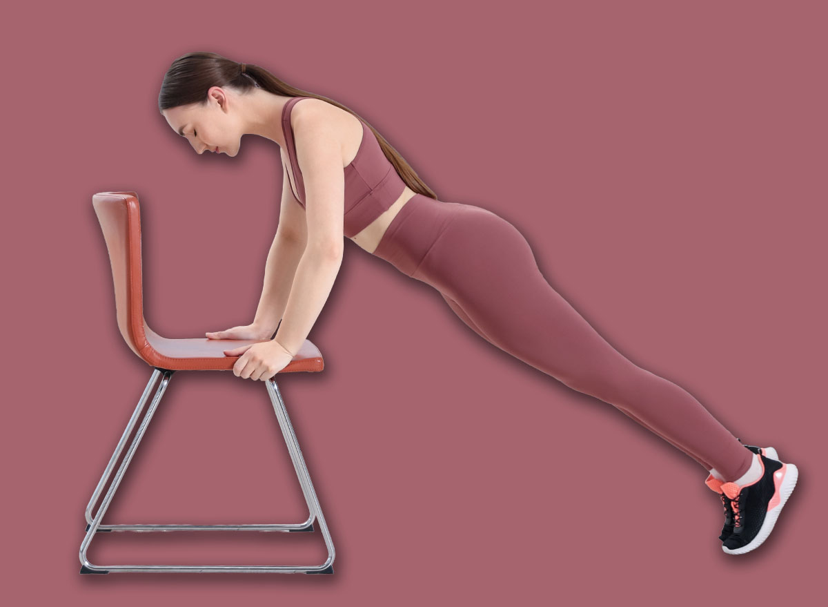 Beautiful woman exercising with chair at home