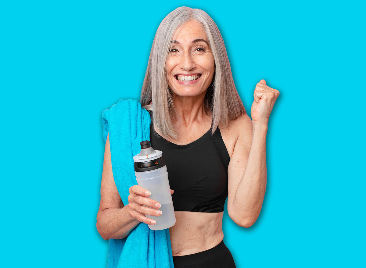 middle age white hair woman feeling shocked,laughing and celebrating success with a towel and water bottle. fitness concept