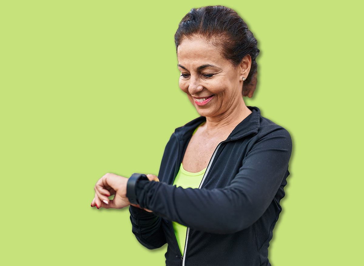 Middle age hispanic woman working out with smart watch outdoors