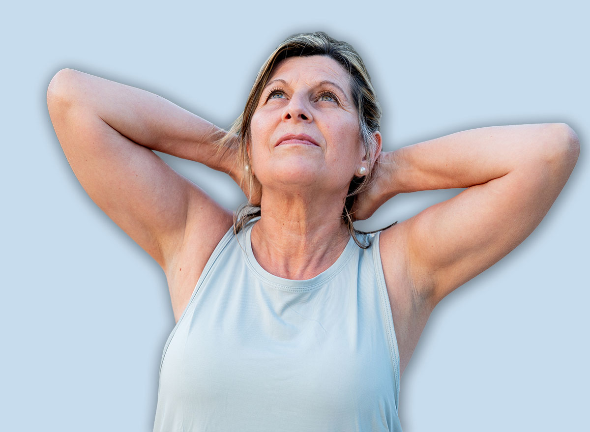 Senior woman stretching her neck and looking up, enjoying a moment of wellness and healthy outdoor activity