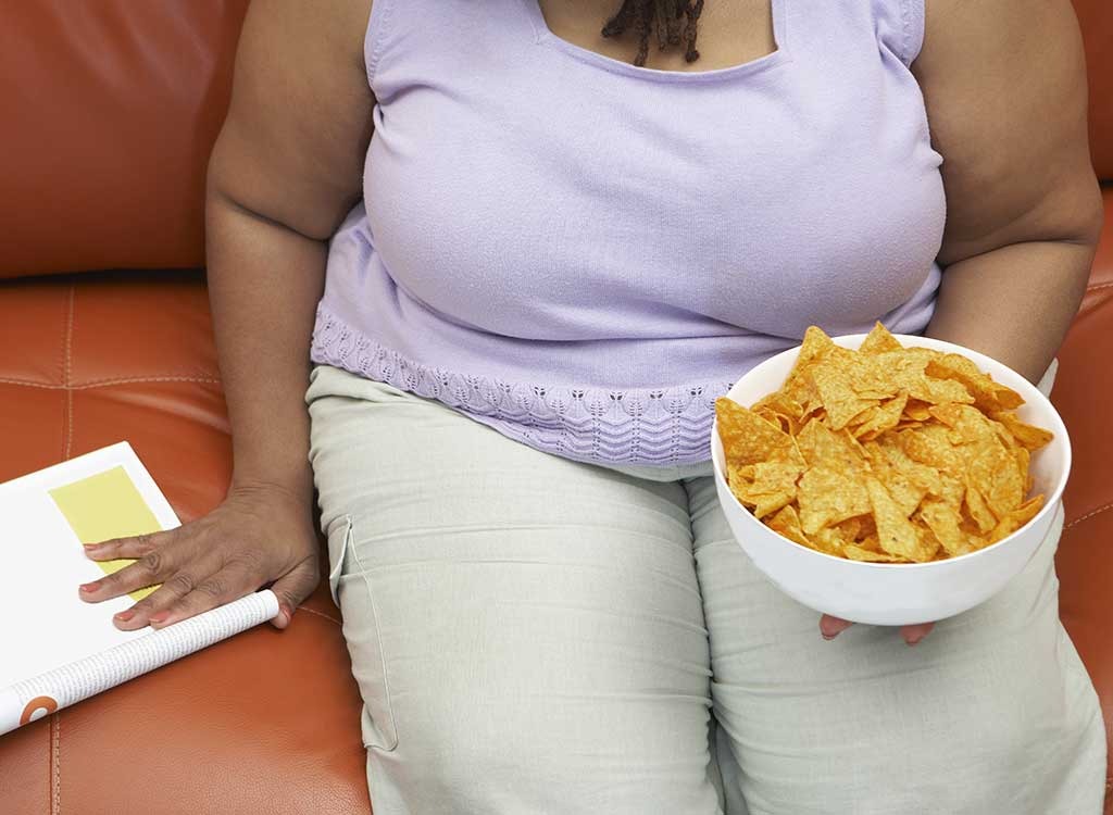overweight woman couch chips