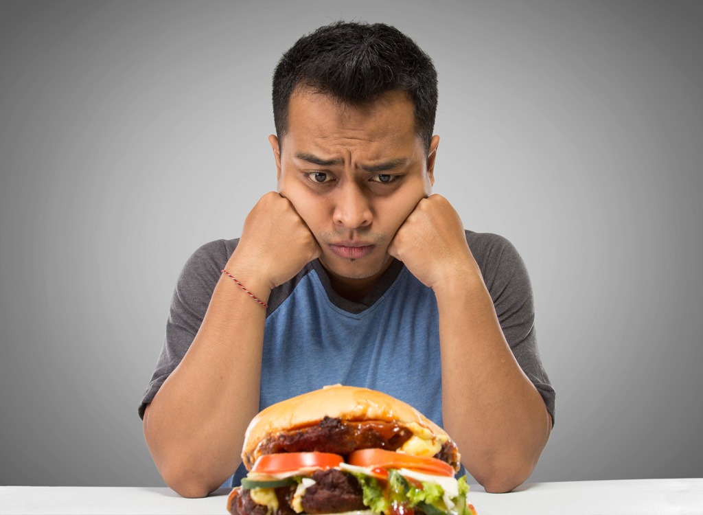 man staring at fast food burger