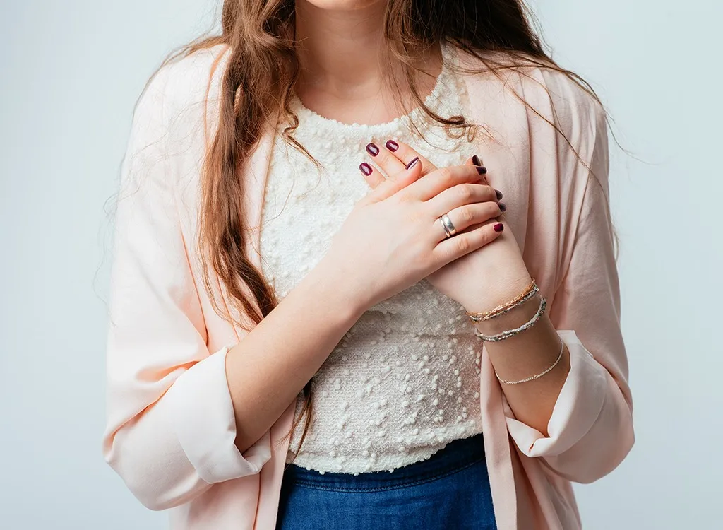 Young woman clutching chest