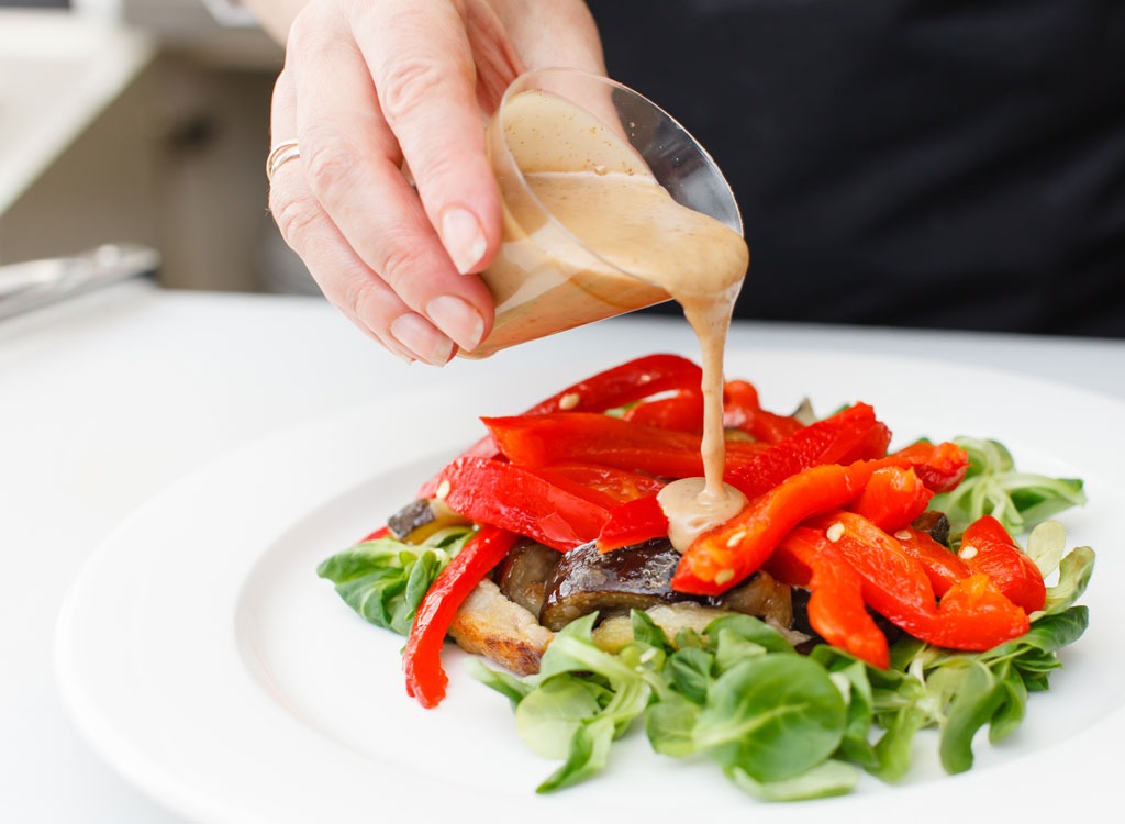 pouring dressing on salad