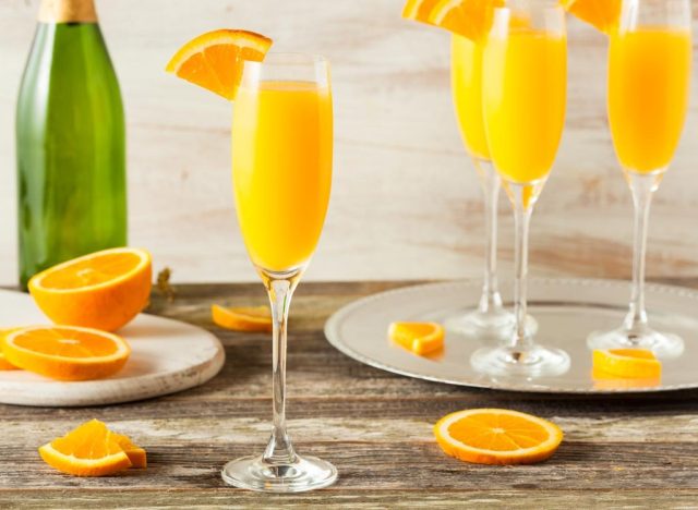 mimosa cocktails in glasses with orange slice on rim
