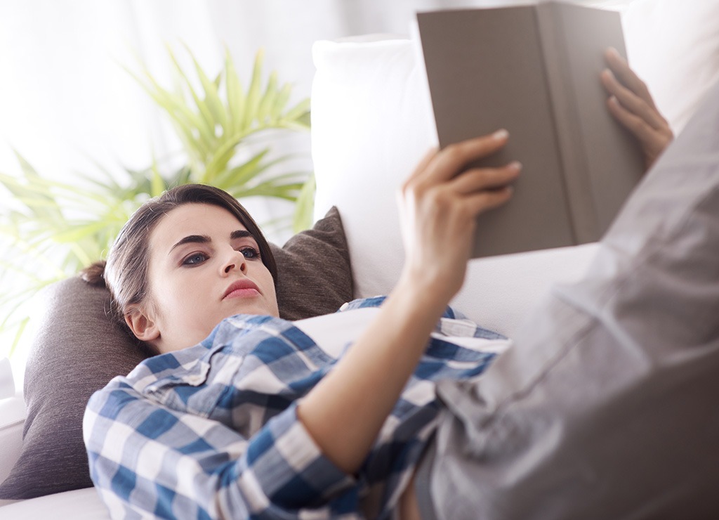 Woman lying down reading book