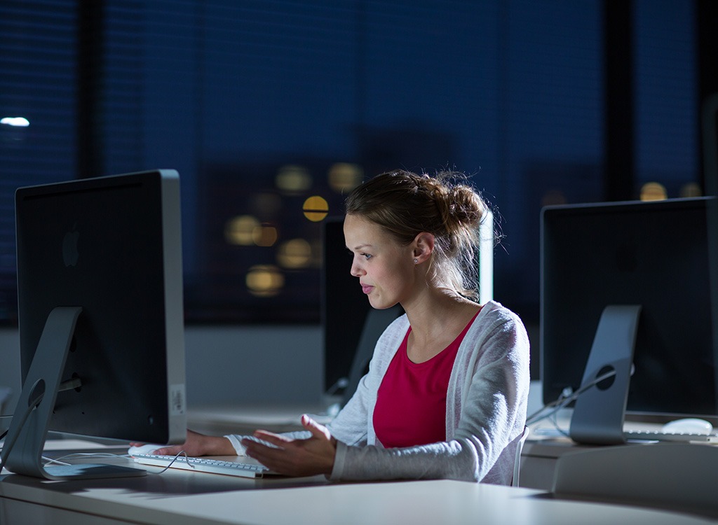 Woman frustrated at work late at night