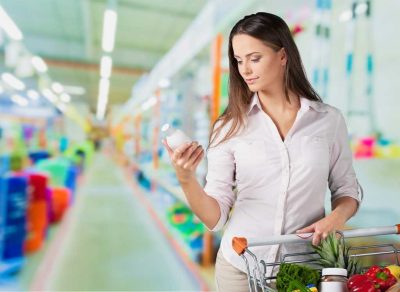 Woman looking at bottle in grocery store