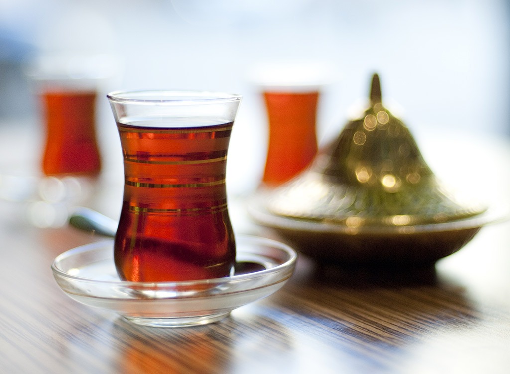 glass of black tea with tea infuser