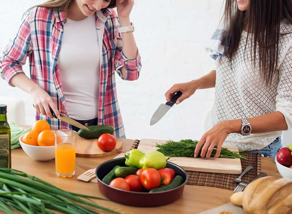 young women slicing & prepping veggies
