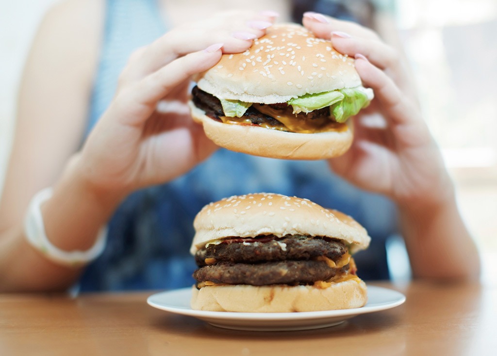 Woman eating two burgers