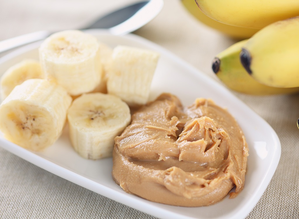 sliced bananas with nut butter on white plate