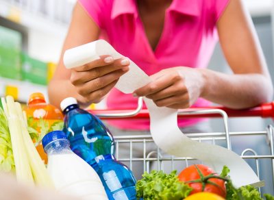 Woman looking at receipt in grocery store