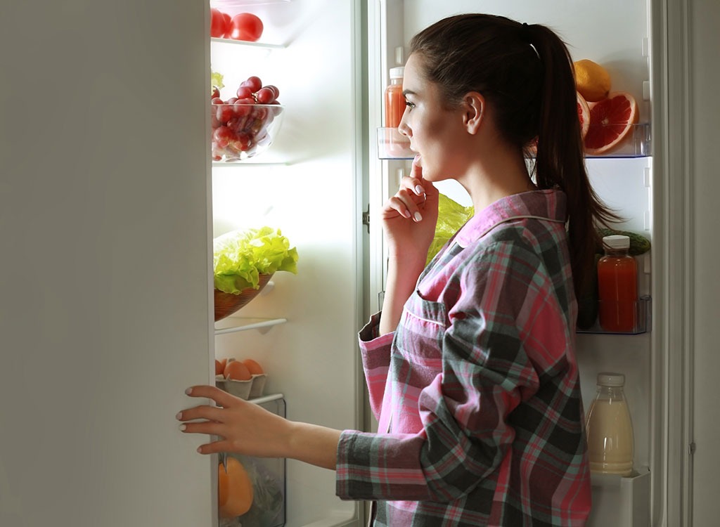 Woman looking in refrigerator late at night - how to lose weight overnight