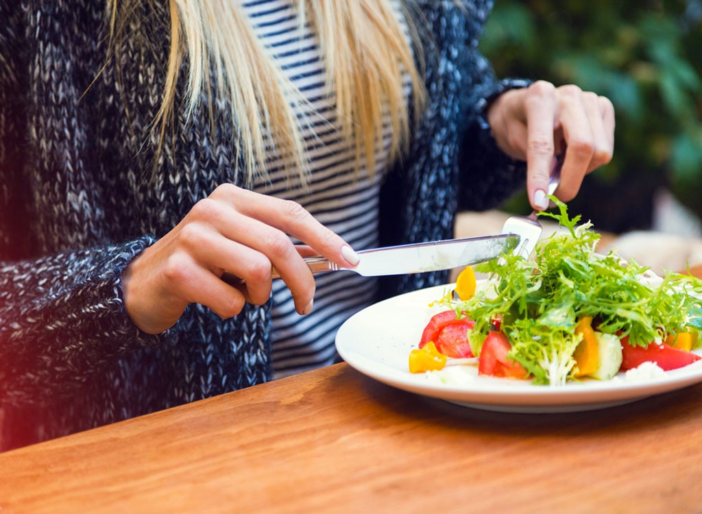 Woman sitting down eating at a table