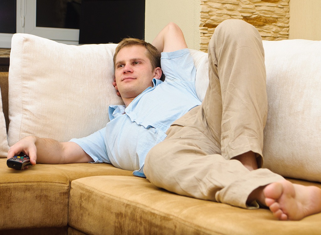 man on couch with remote