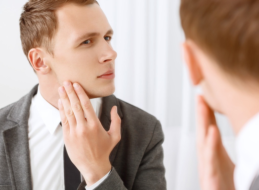 Young man looking in mirror