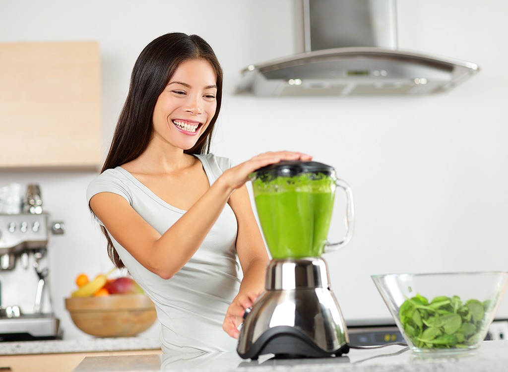 woman making green smoothie