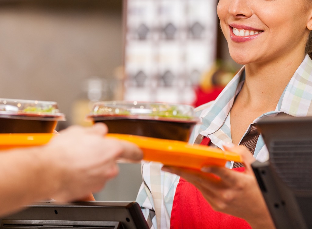 Fast food server giving customer a tray of food