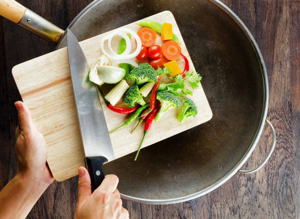 dropping veggies into skillet