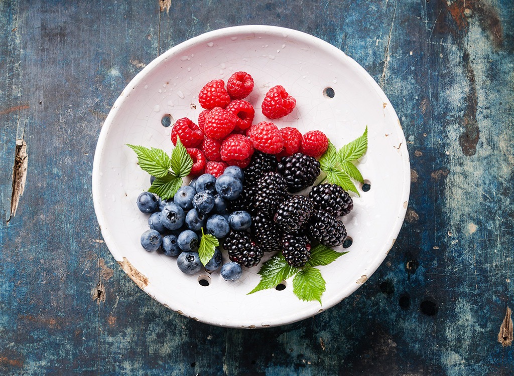 Mixed blueberries raspberries blackberries on plate - muscle building foods