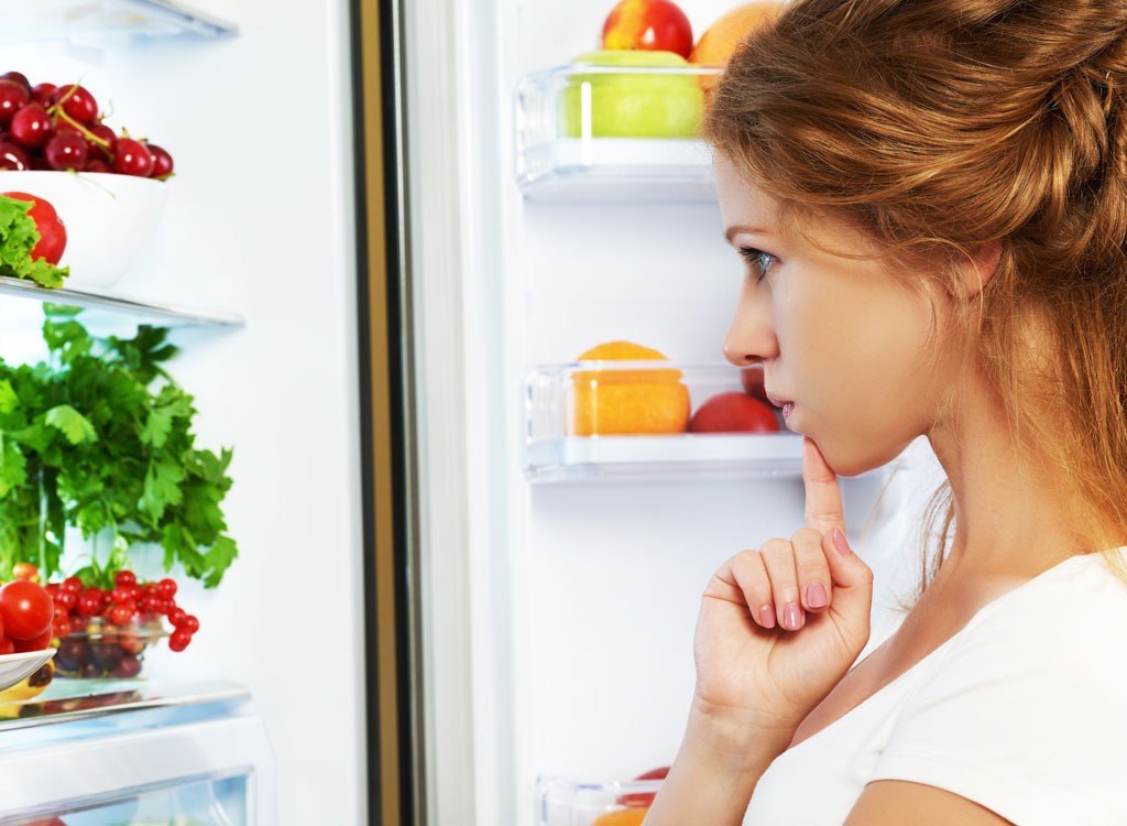 Woman looking in refrigerator - stop thinking about food