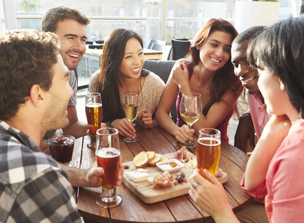 gruppo di amici che bevono birra e mangiano un antipasto