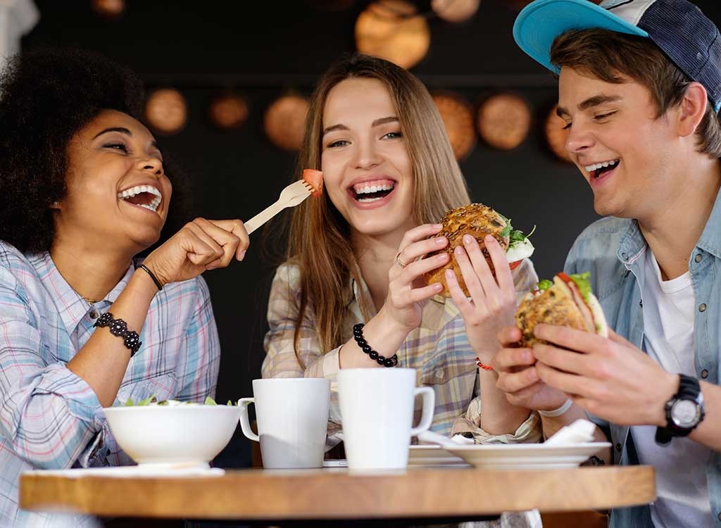 Friends laughing together while eating