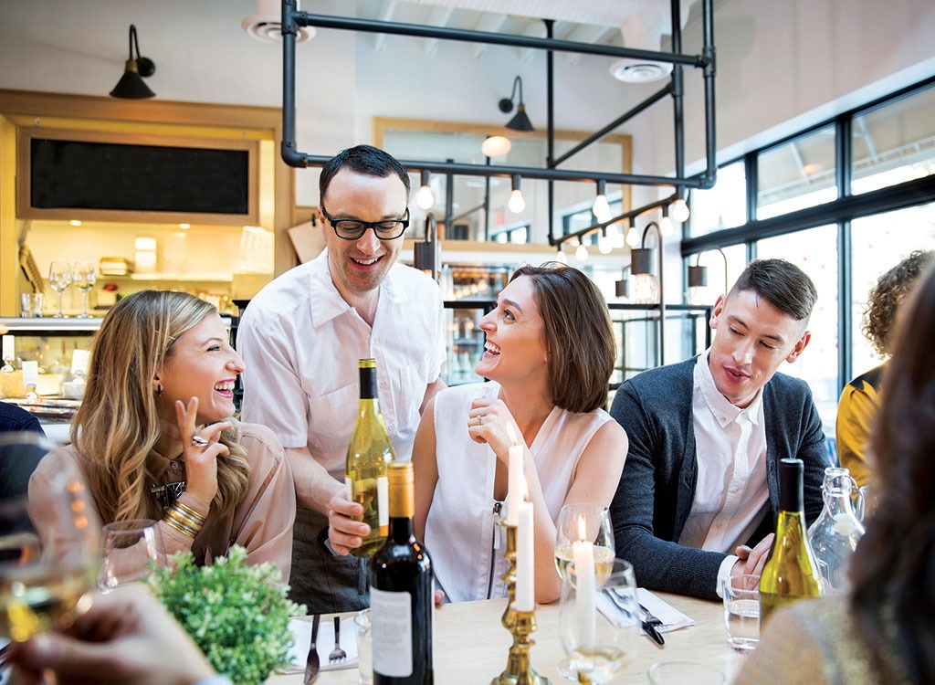 kvinnor skrattar och pratar med servitören