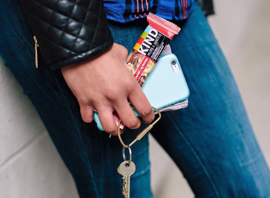 woman holding kind bar and cellphone