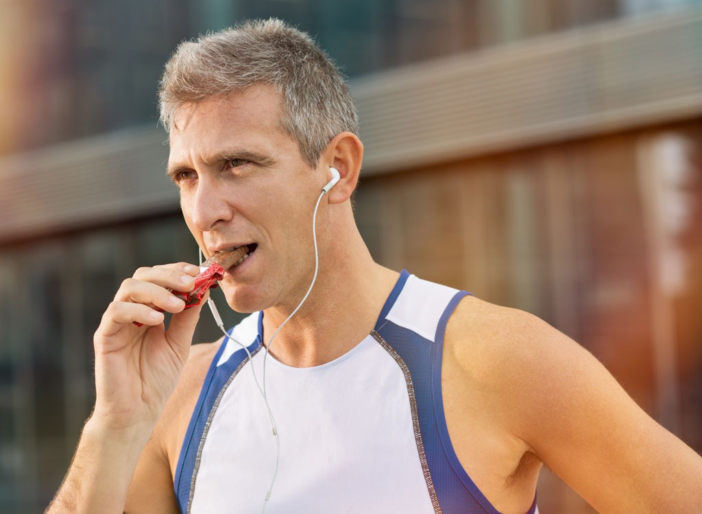 Older man eating protein bar