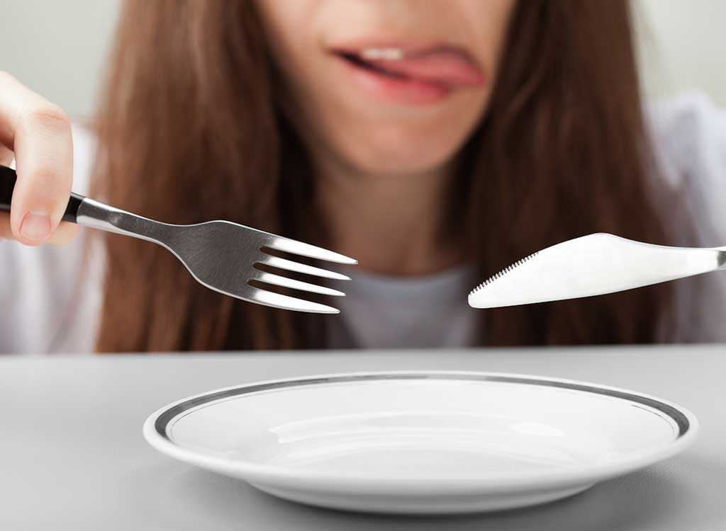 Hungry woman fork knife empty plate - what happens when you dont drink enough water