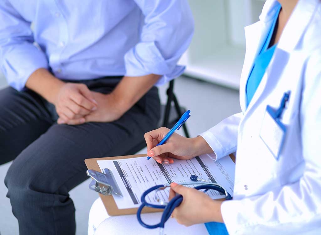 Doctor writing on clipboard