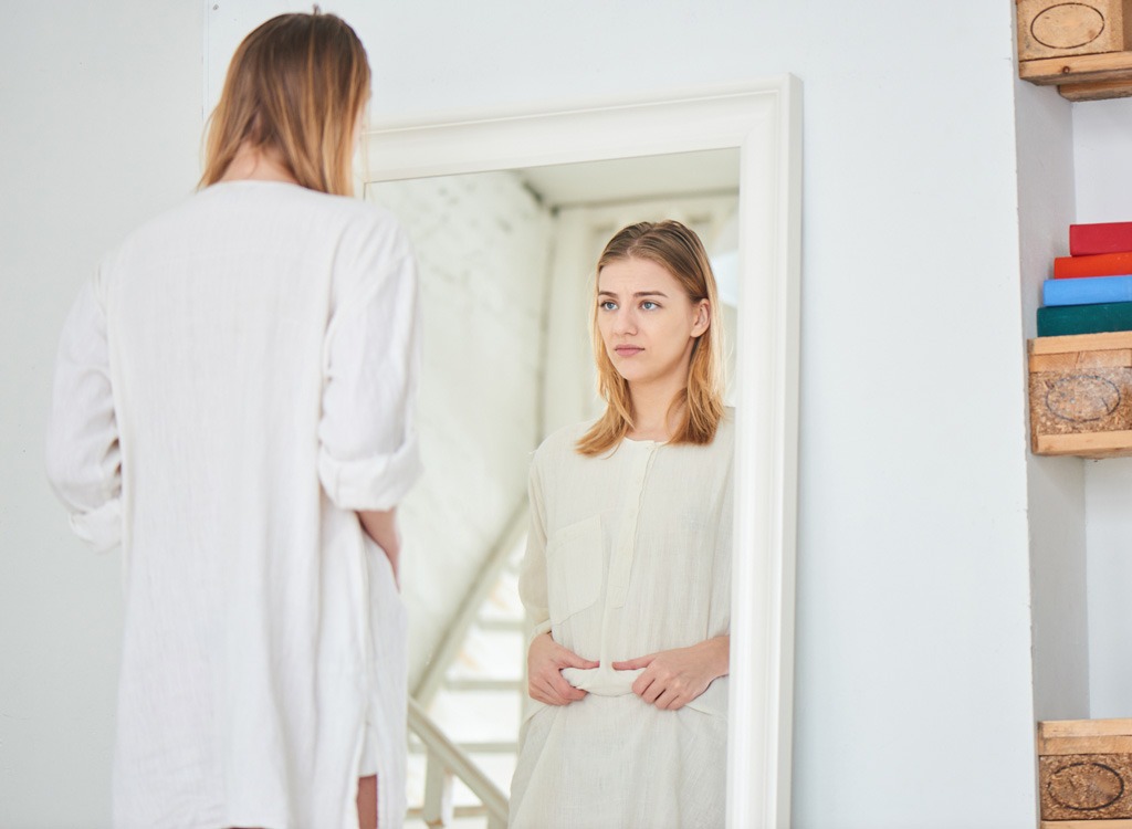 Woman looking at herself in mirror