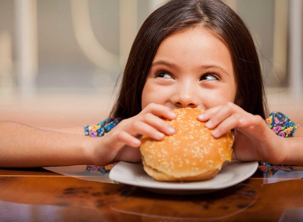 Little girl eating burger