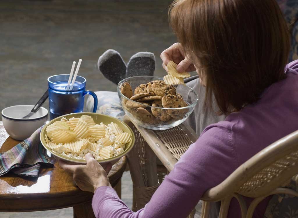 Woman eating chips and cookies