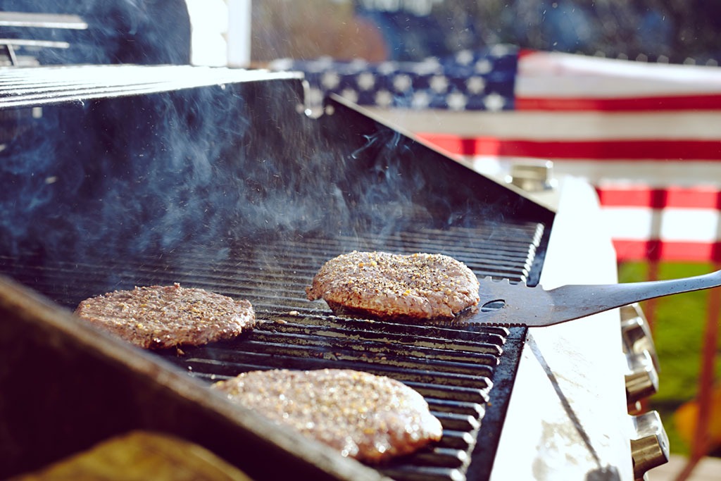 flipping burgers on grill