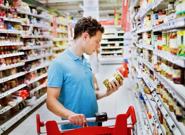 man reading label in supermarket