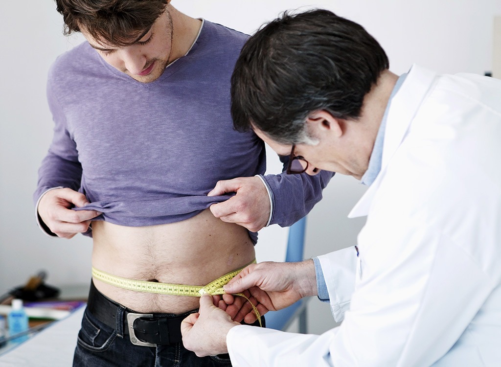 man getting waist measured