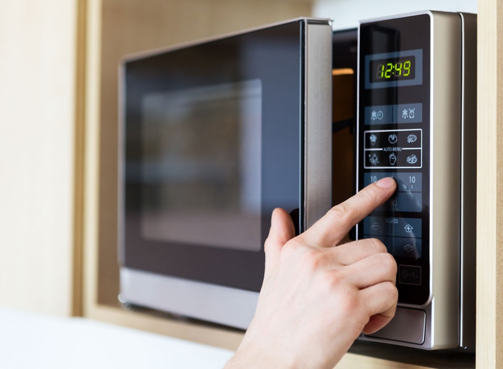 person using microwave