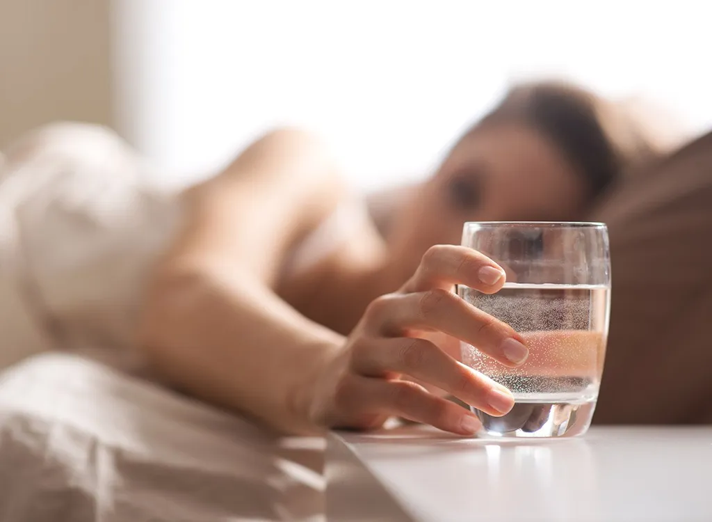 woman reaching for water glass