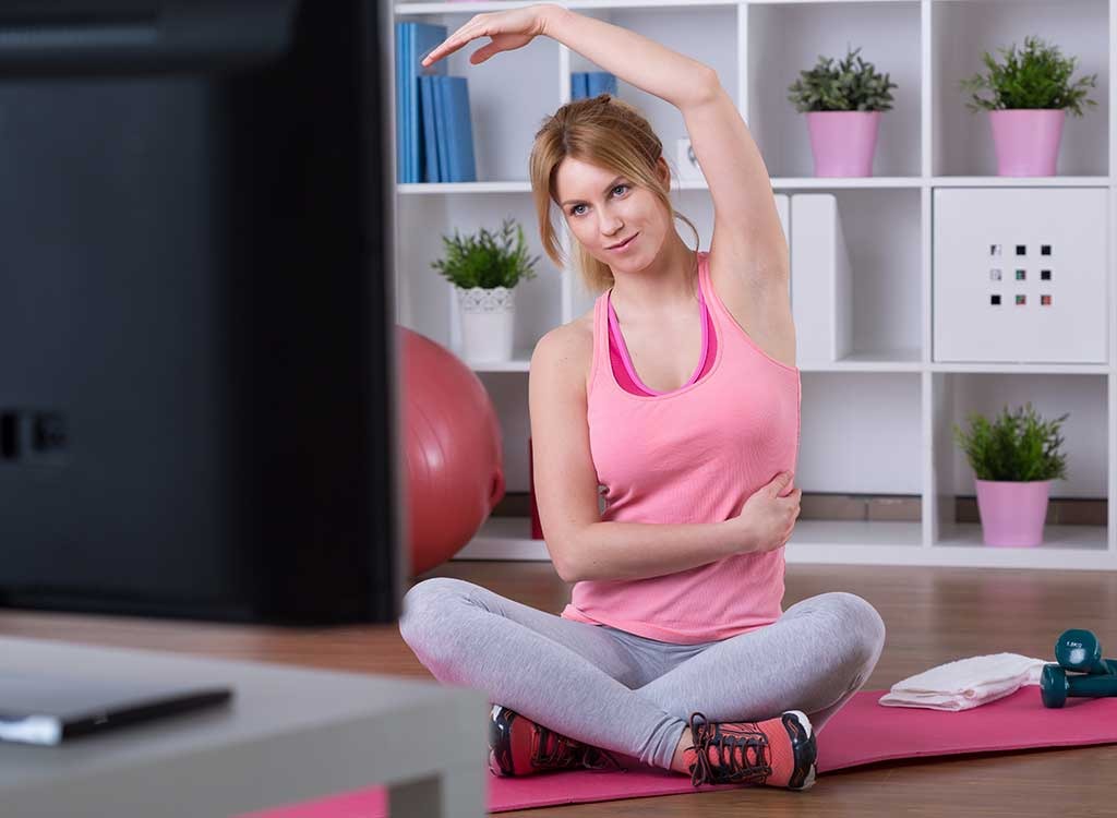 woman stretching in front of tv