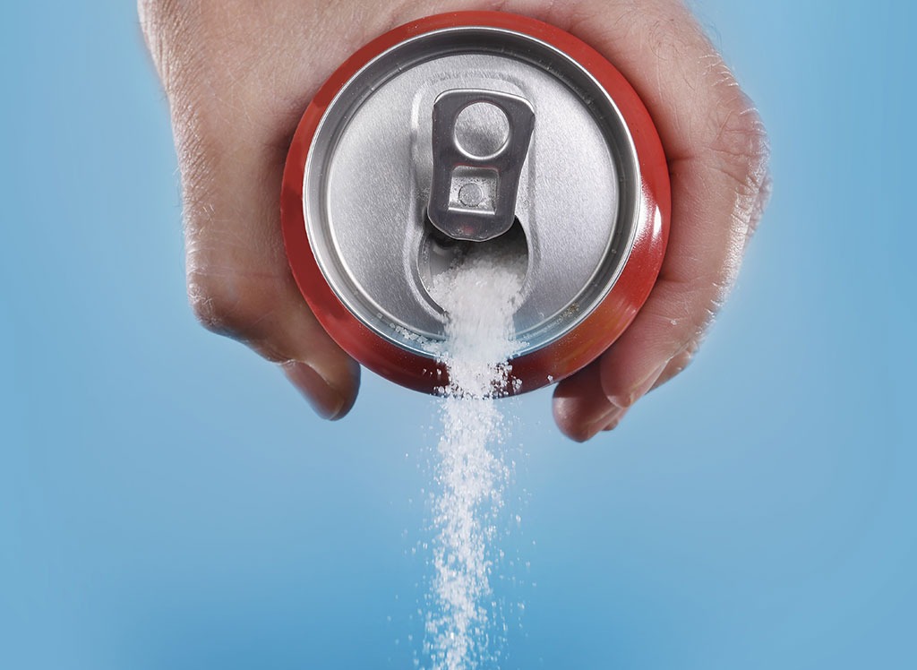 pouring sugar out of soda can