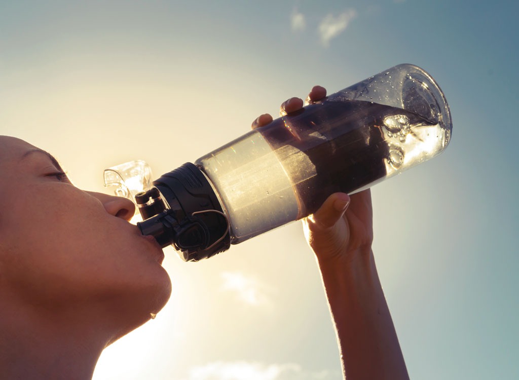 woman drinking from water bottle