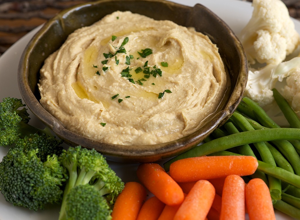 hummus in bowl served with raw vegetables